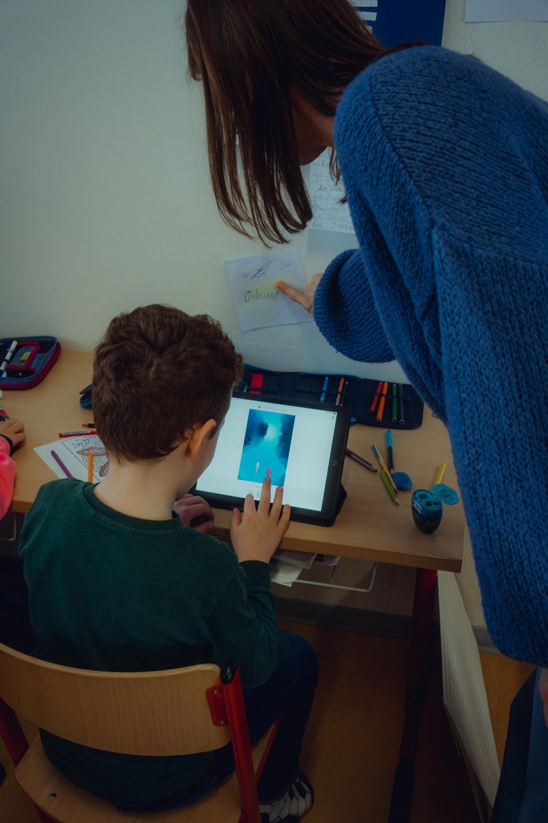 Kind und Lehrerin, mit Tablet arbeitend