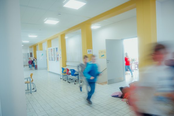 Flur mit Kindern, die in die Pause rennen
